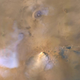 A dust tower (bottom center) is seen in this NASA MRO photo from 2011. The bluish-white plumes at left are water vapor clouds.